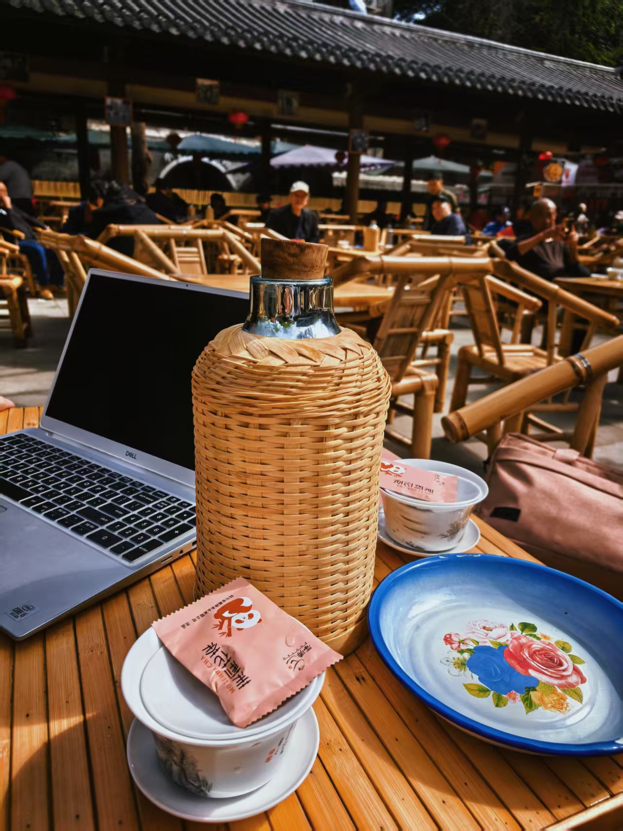Laptop, gaiwan and woven thermos on one bamboo table