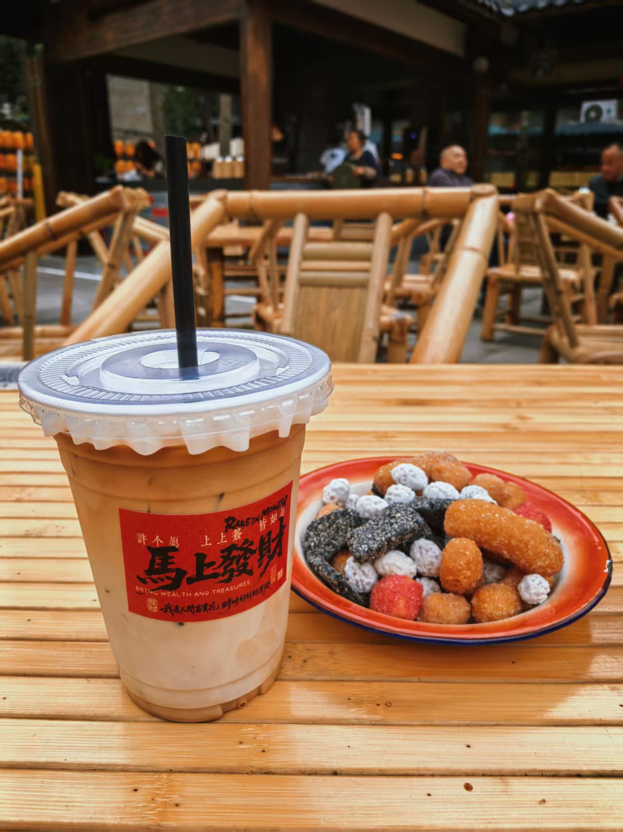 Iced latte with a plate of fried night-market snacks
